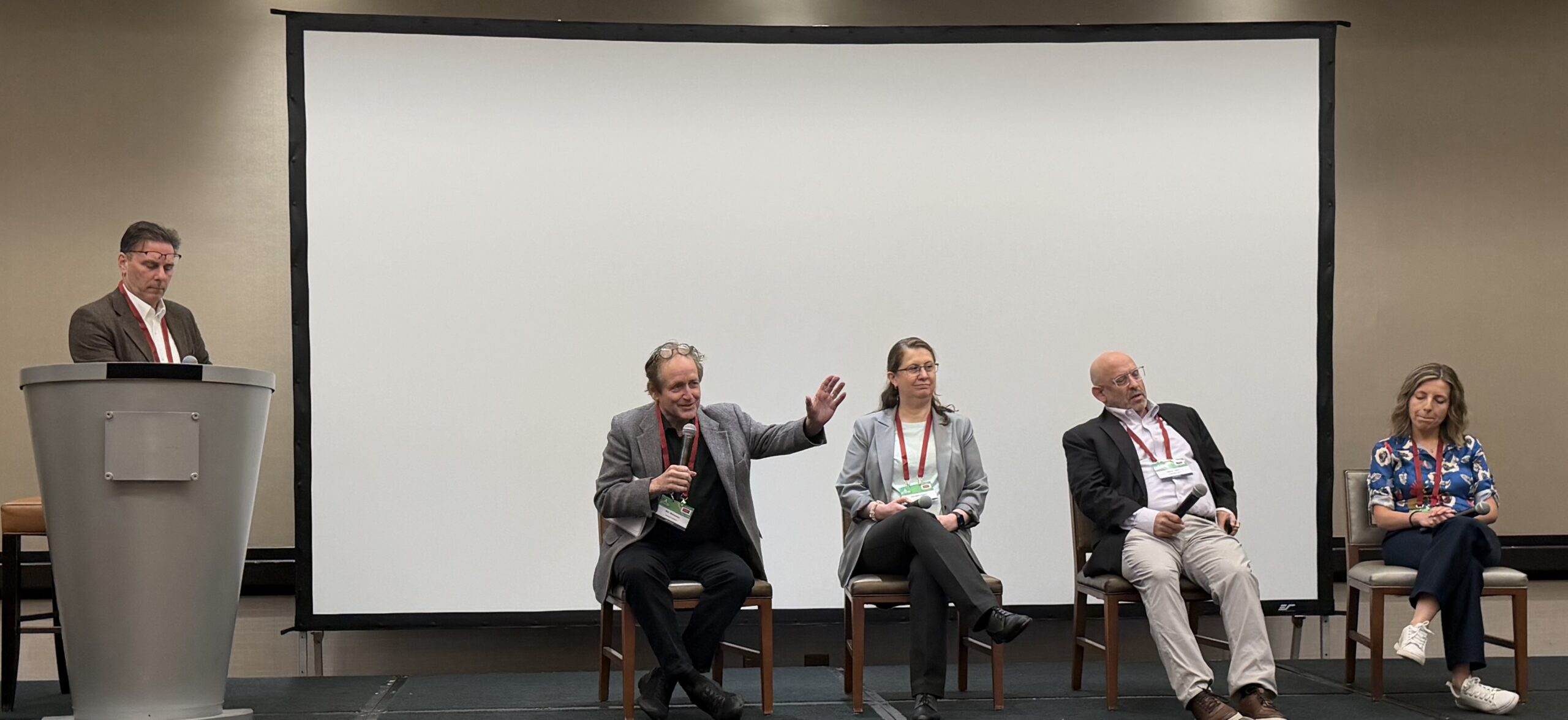 Bill Shireman speaking into a microphone on a four-person panel on stage at Sustainable Plastics USA 2026 in Los Angeles.